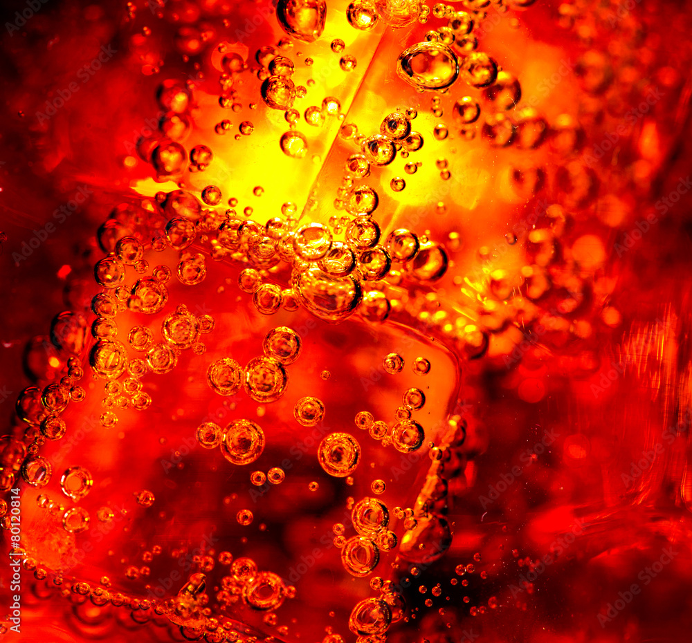 Cola background. Cola with Ice and bubbles in glass closeup