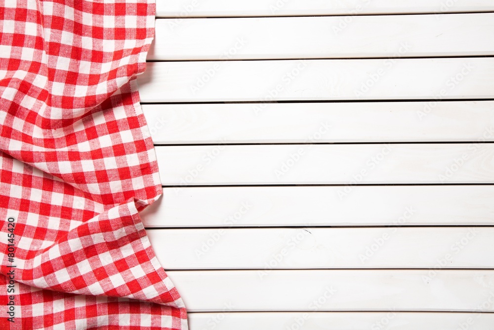 Picnic. red folded tablecloth over bleached wooden table