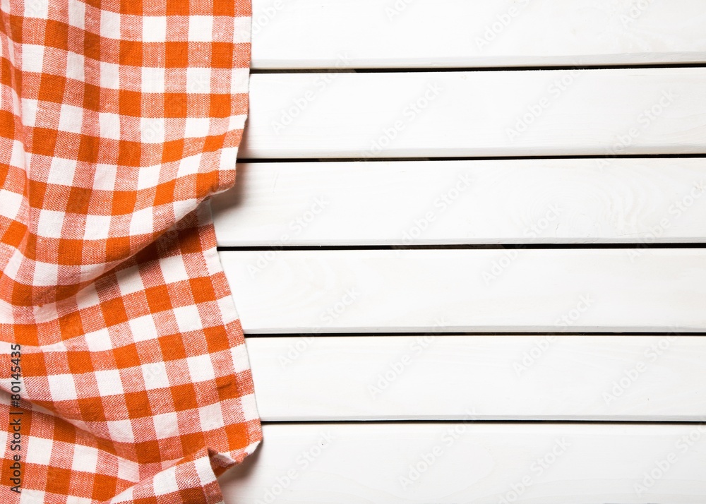 Picnic. red folded tablecloth over bleached wooden table