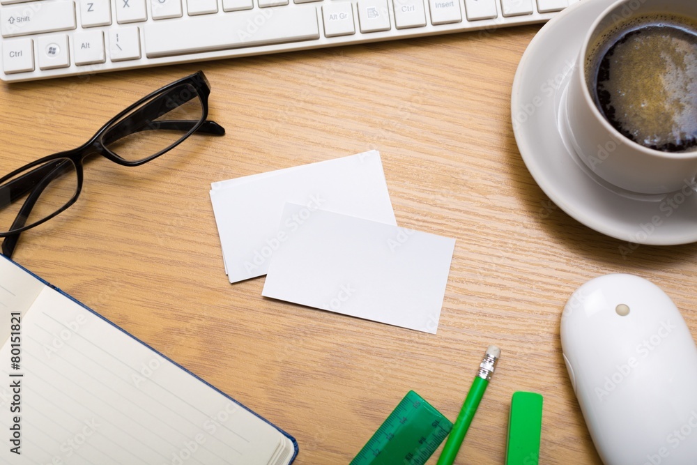 Desk. Blank business cards with supplies and coffee cup on