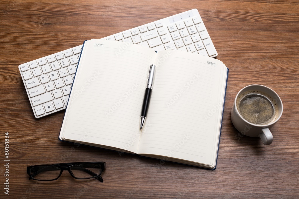 Laptop. Blank notepad and coffee cup on office wooden table