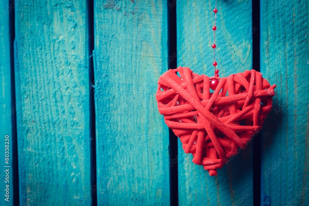 Love. Rustic wooden red heart hanging on the weathered old white