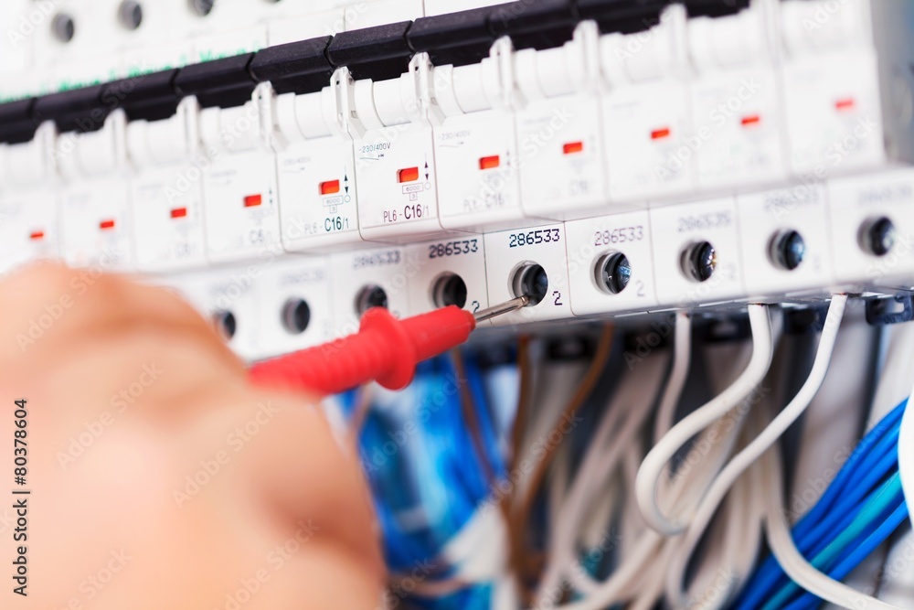 Engineer. Hand of an electrician with multimeter probe at an