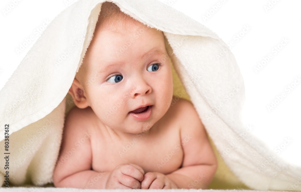 Smiling. Smiling baby looking at camera under a white blanket