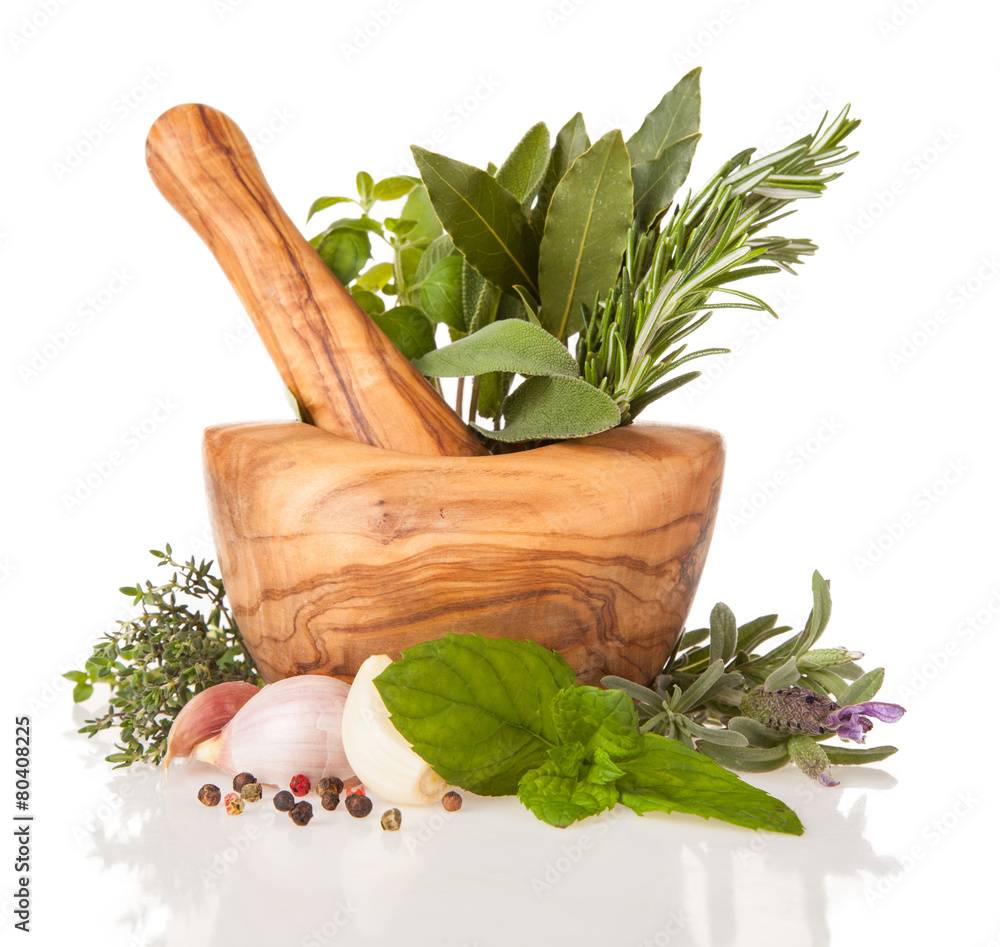 Wooden mortar with herbs on white background