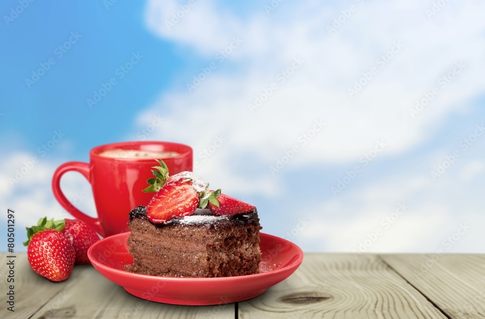 Closeup. Delicious chocolate cake with cream and berries and cup