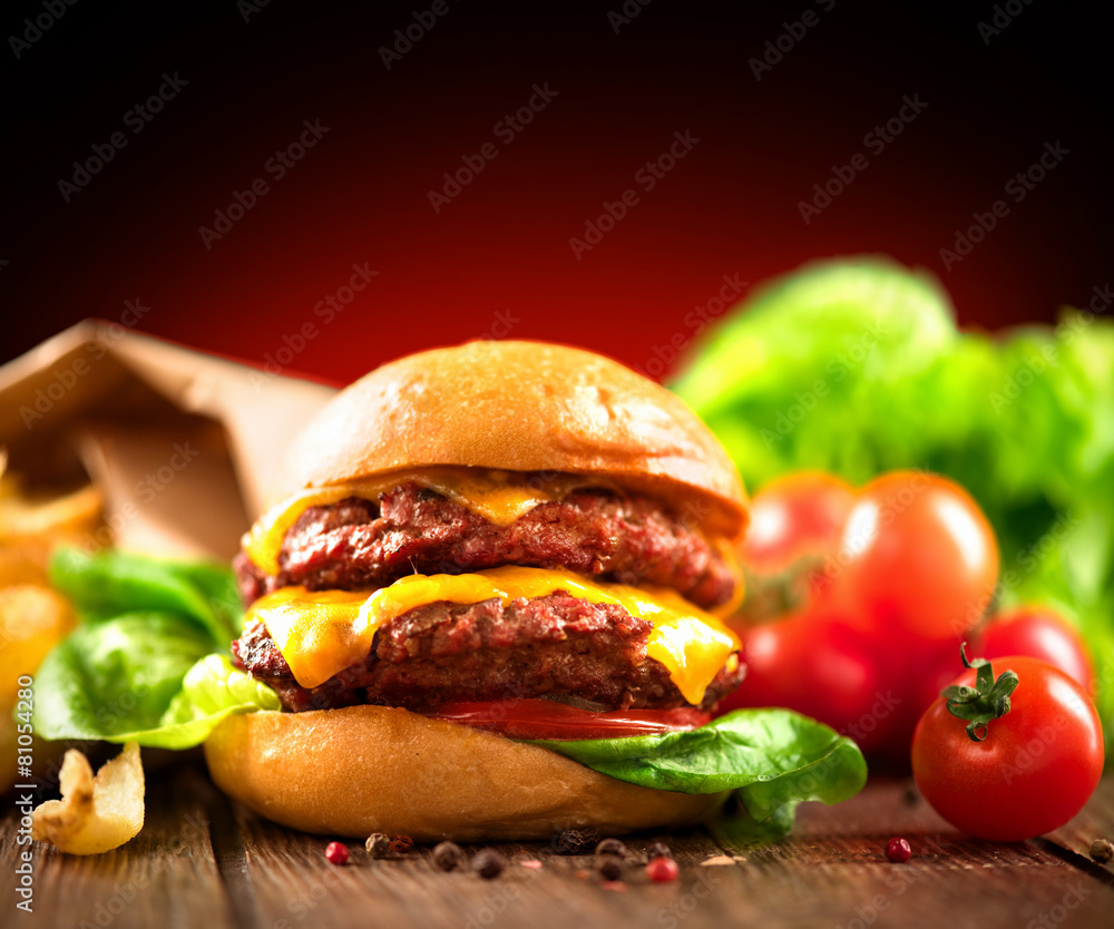 Cheeseburger with fries on wooden table