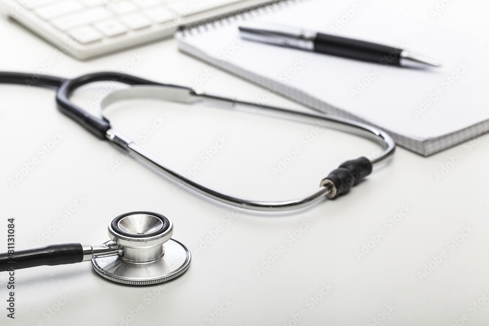 Laptop. Stethoscope on doctor's desk with keyboard and pad