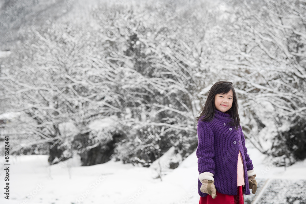 可爱的亚洲女孩在雪地里微笑