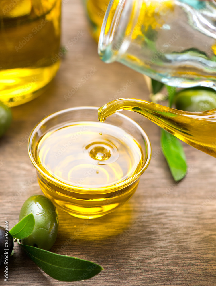 Virgin olive oil pouring in a bowl closeup. Dieting concept