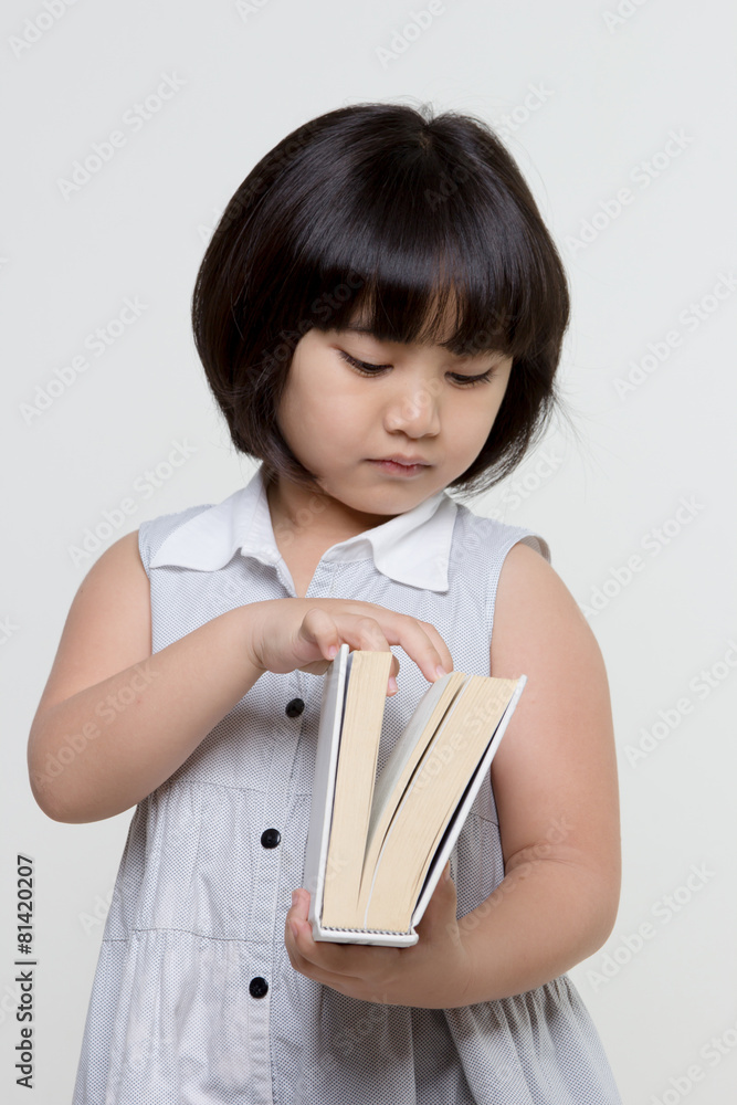 Portrait of little lovely Asian child opening a book