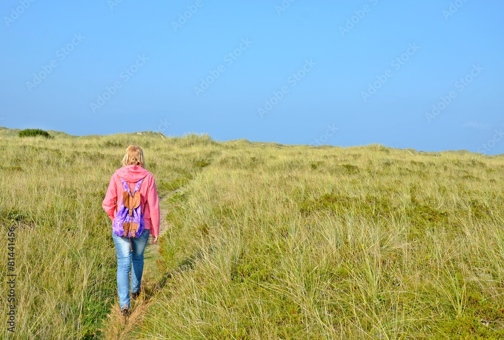 Frau spaziert in den Dünen