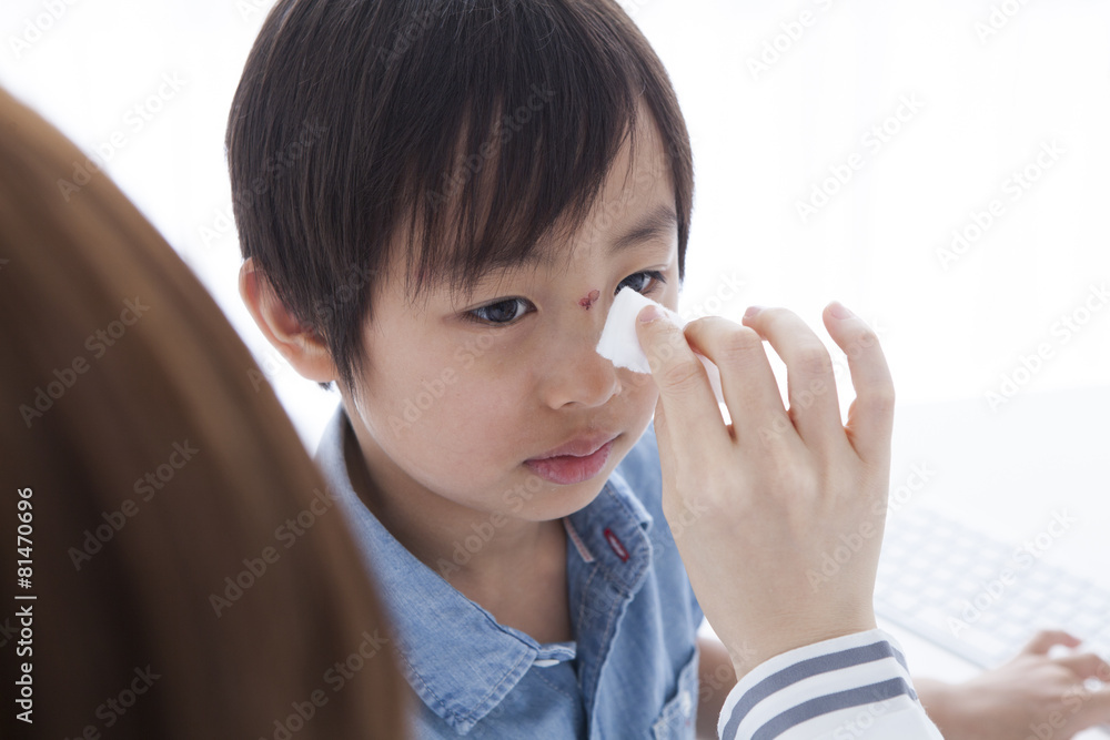 医生正在治疗男孩前额的伤口