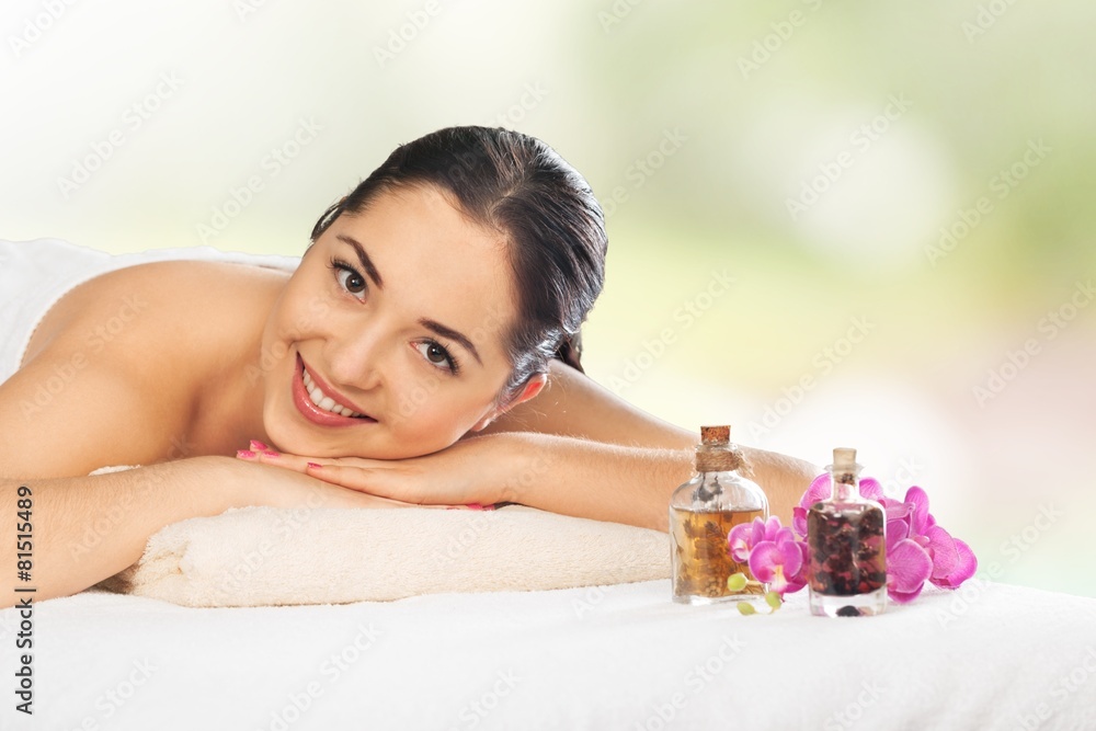 Oil. Beauty and spa concept - happy woman in spa salon lying on