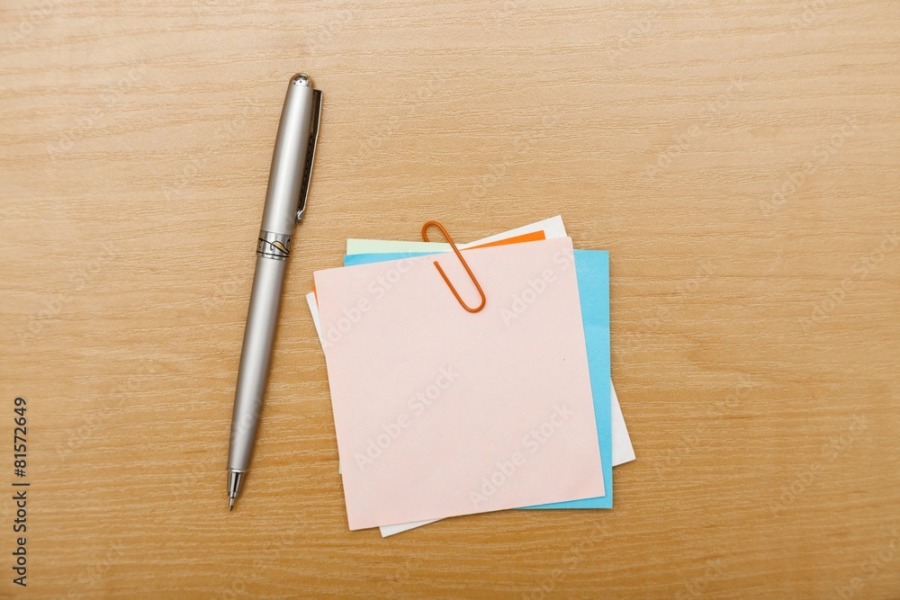 Post. Blank post-it with pen on office wooden table. Above view