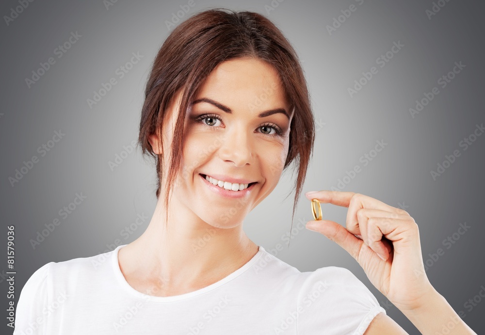 Vitamin Pill. Woman showing Omega 3 fish oil capsule, isolated