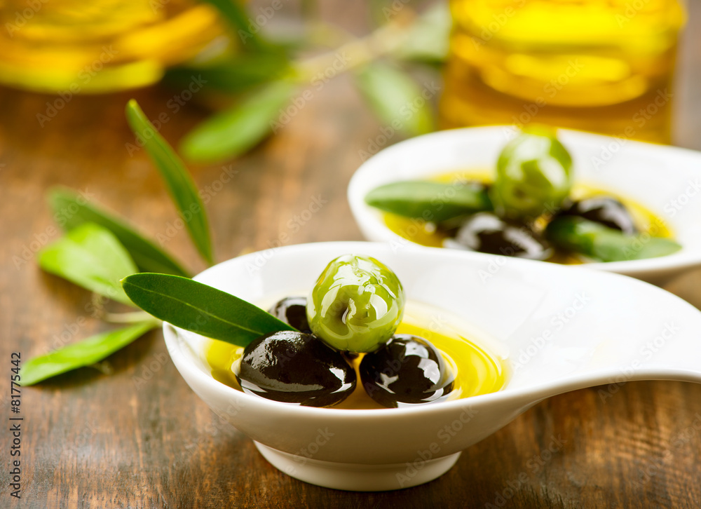 Olives and olive oil on the wooden table