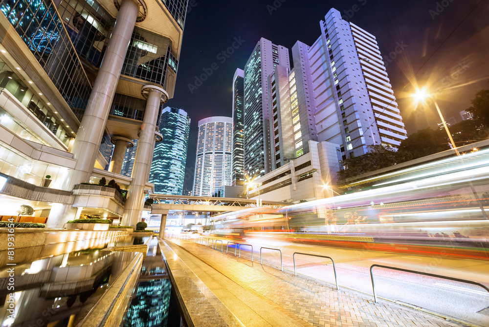 traffic light trails and office buildings in modern city