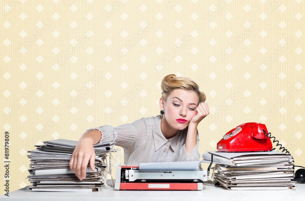 Desk. A bored office worker sitting behind a large stack of