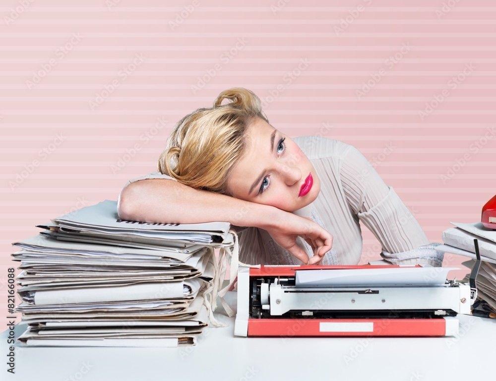 Desk. A bored office worker sitting behind a large stack of