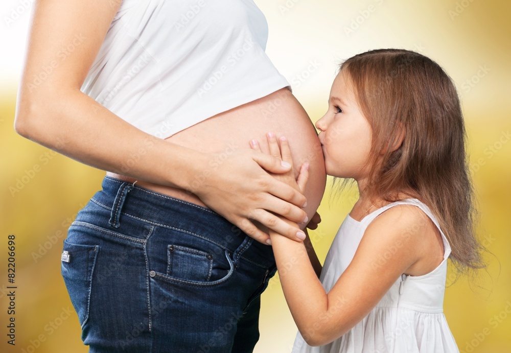 Pregnant. Kid girl listening with can pregnant mothers stomach