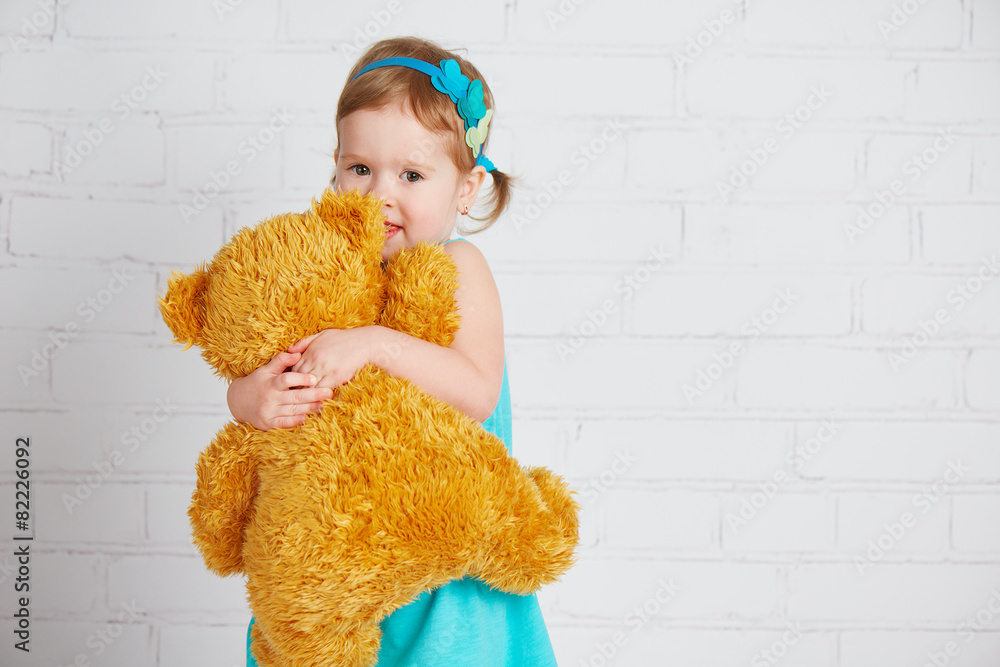 baby girl hugging a loved teddy bear