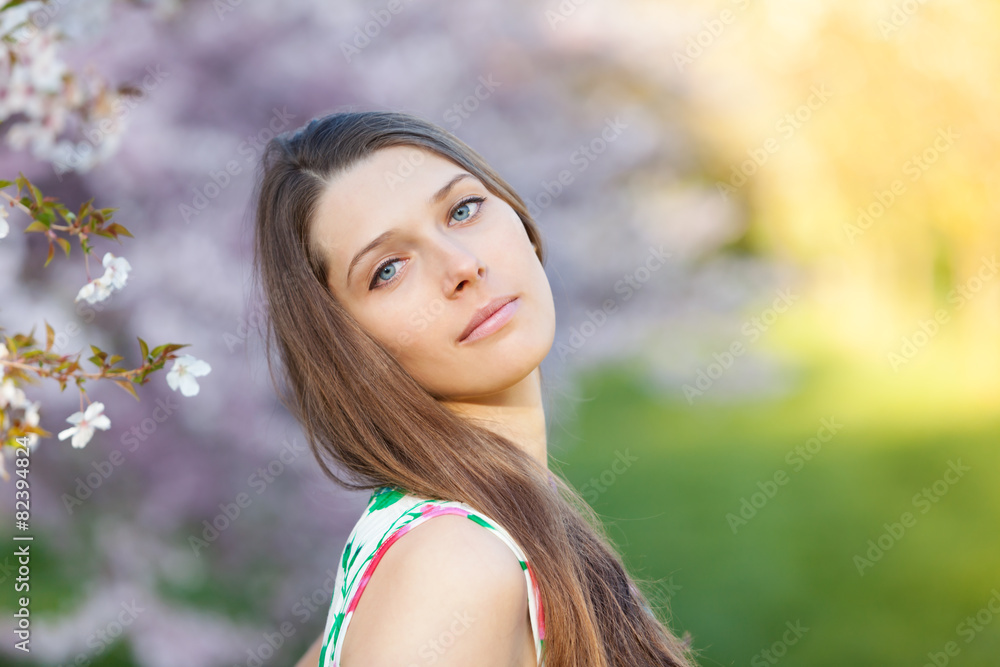 Beautiful  brunette woman in blooming orchard