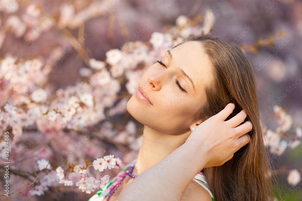 Beautiful  brunette woman in blooming orchard