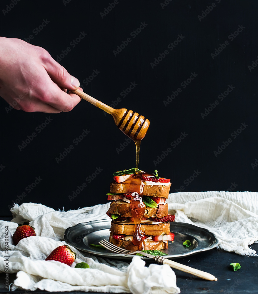 French toasts tower with strawberry, cream cheese and mint, hand