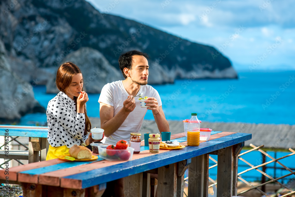 Young couple having breakfast outdoors