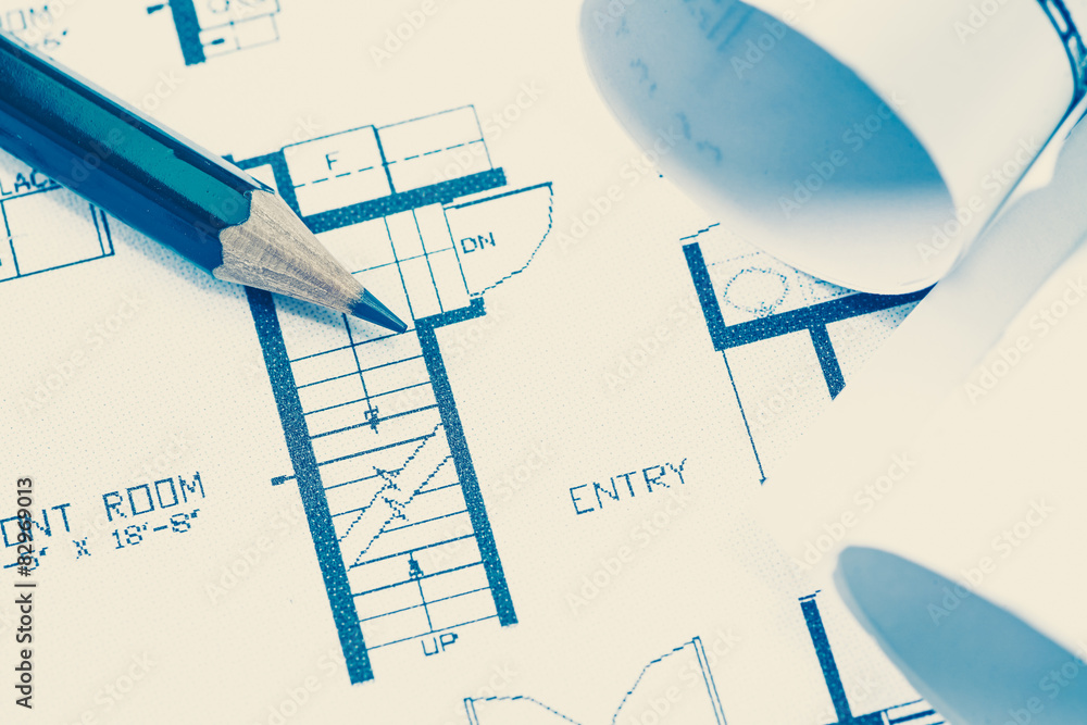 Architect rolls and plans construction project drawing..