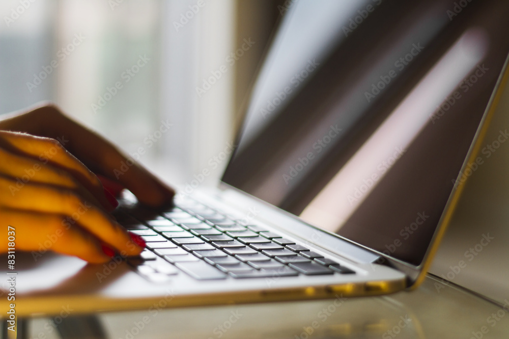 Female hands typing on  a laptop, shallow depth of field