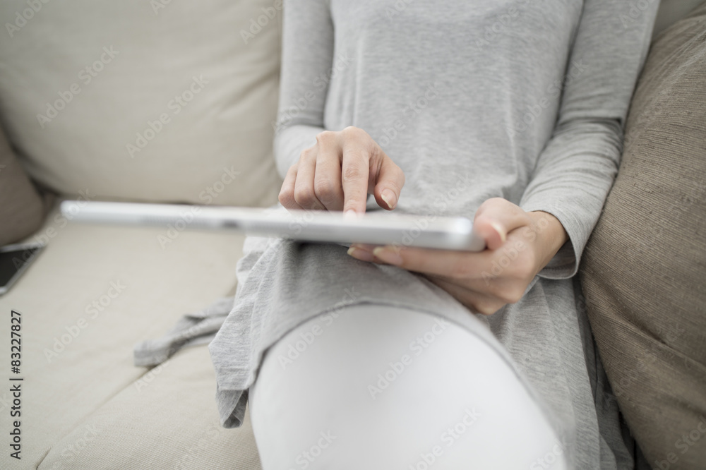 Women are looking at the tablet on the sofa