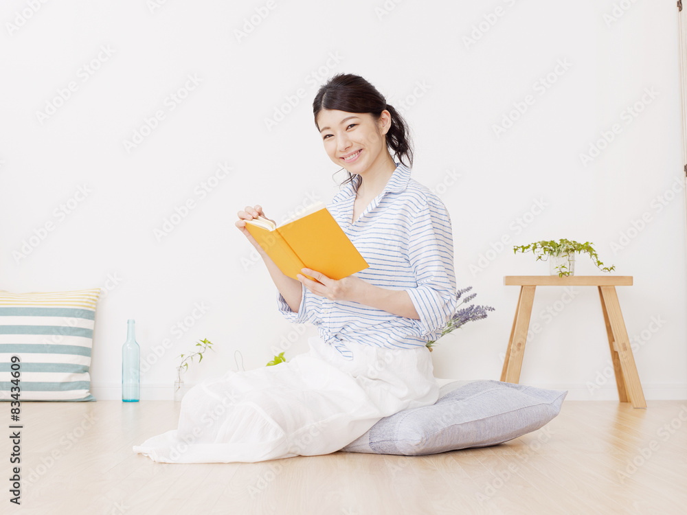 部屋で本を読む女性