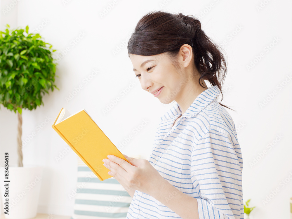 部屋で本を読む女性