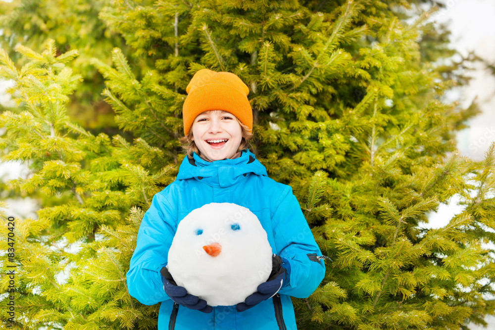 在森林里抱着雪人的大笑男孩