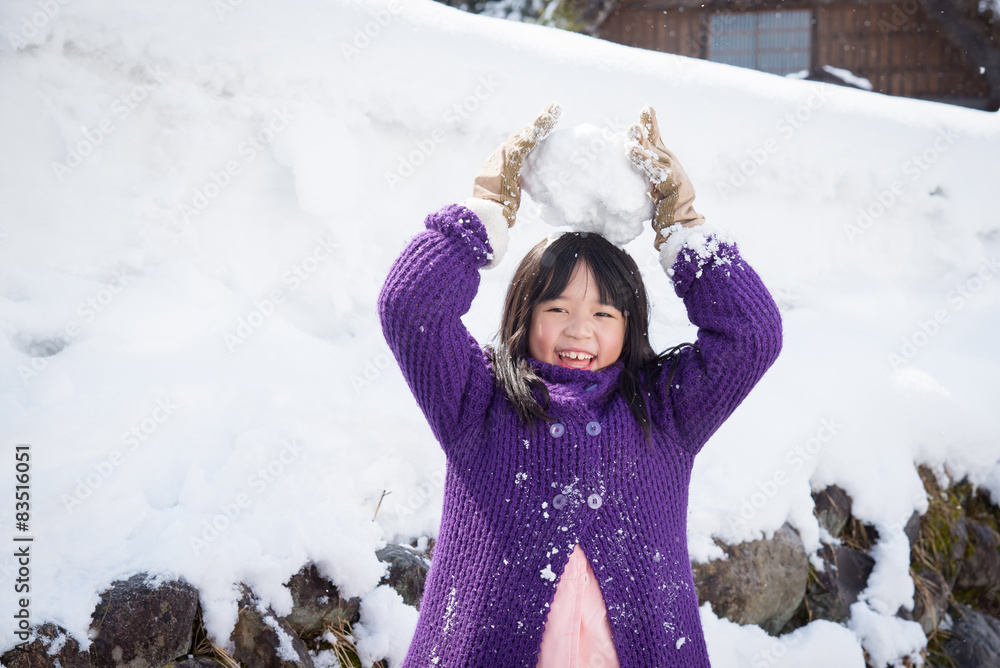 可爱的亚洲女孩在雪地里微笑