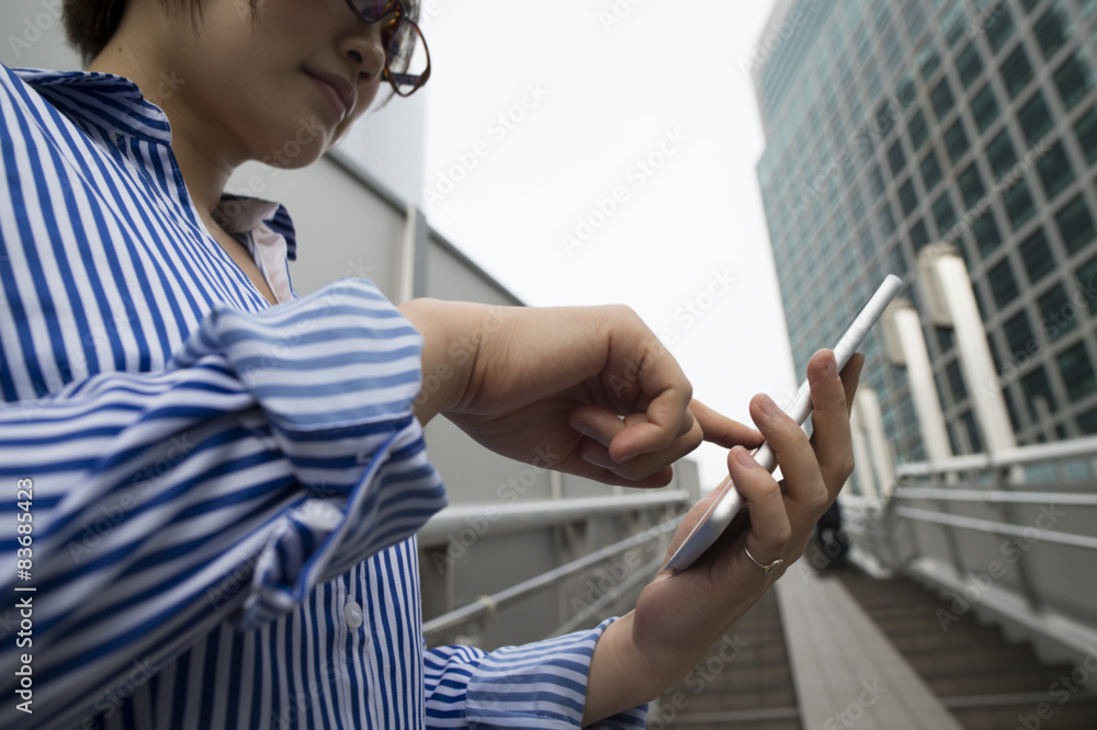 一名女子在人行天桥下看智能手机