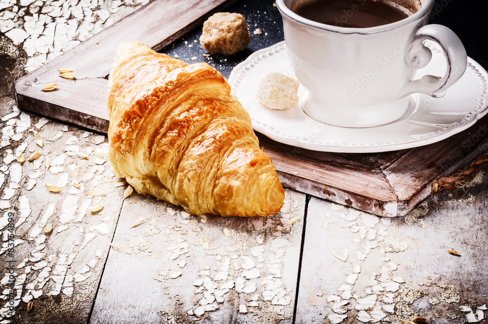 Breakfast setting with coffee and fresh croissant