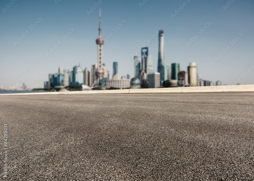 Asphalt road in front of the modern city， in Shanghai，china。