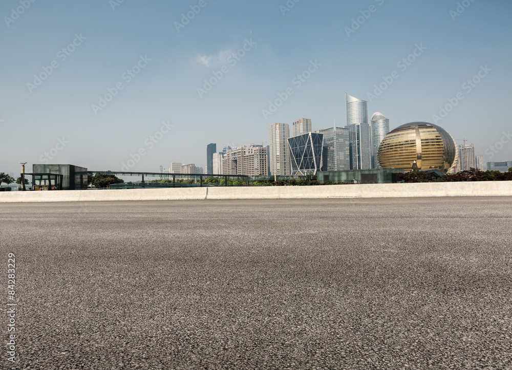 Asphalt road in front of the modern city， in hangzhou，china。