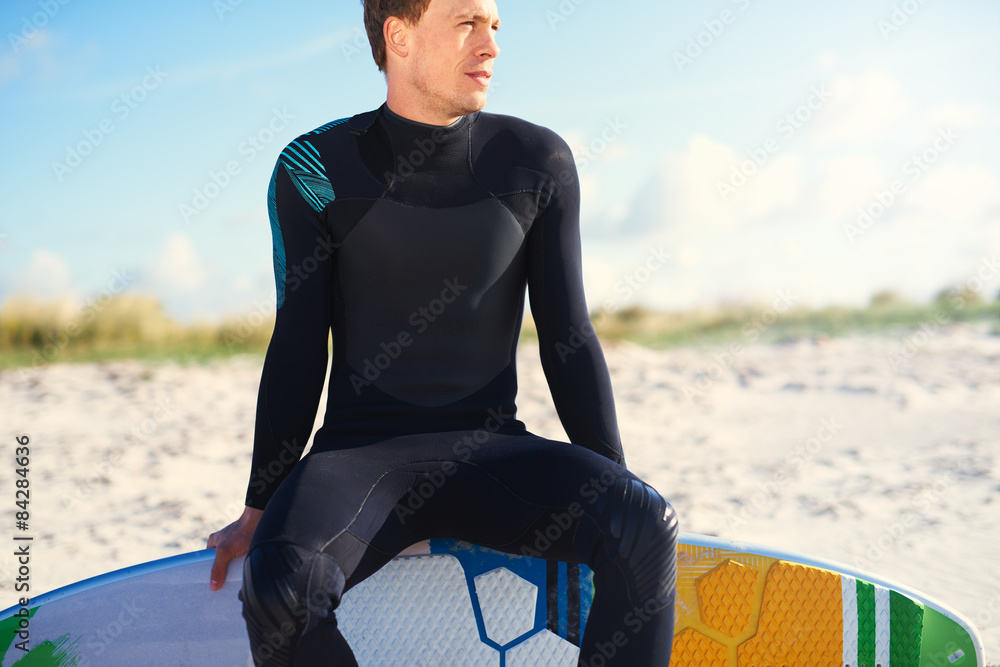 Surfer sitting balanced on the edge of his board