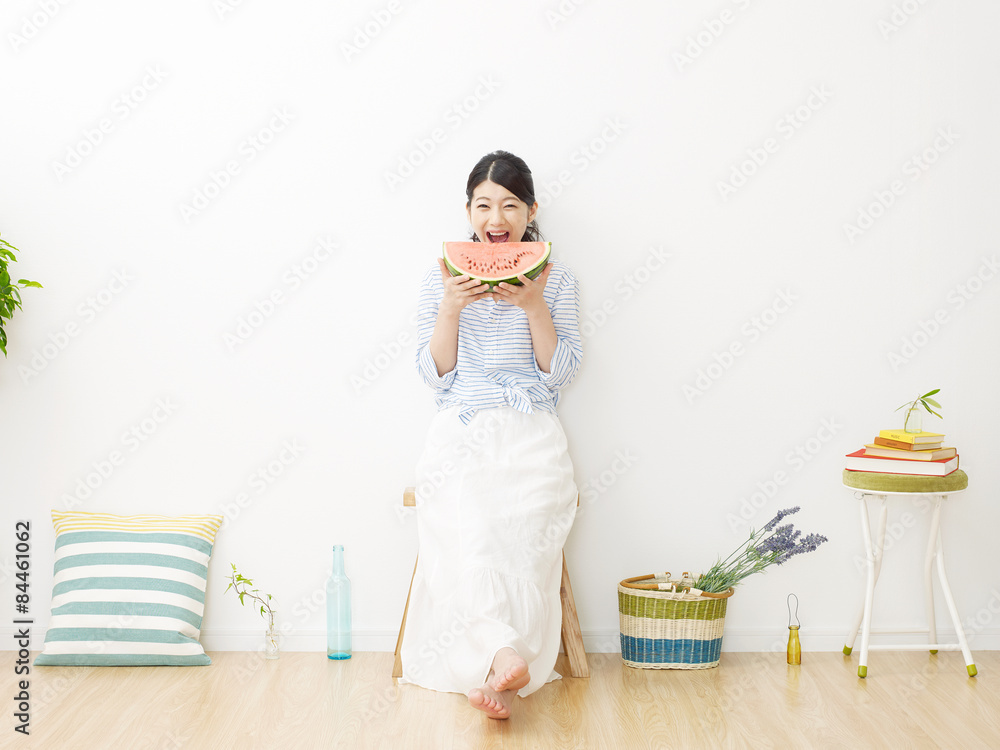 部屋で西瓜を食べる女性