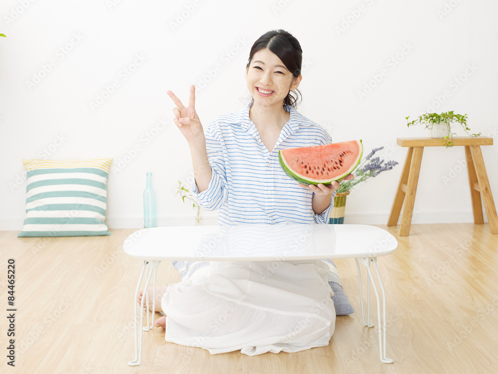 部屋で西瓜を食べる女性