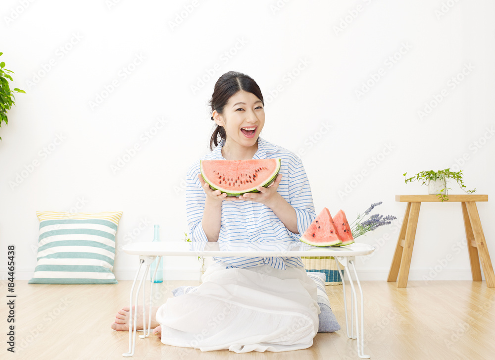 部屋で西瓜を食べる女性