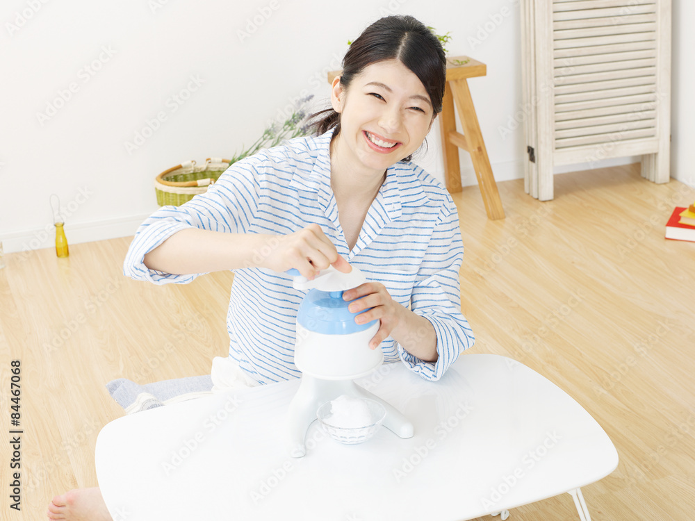 部屋でかき氷をする女性