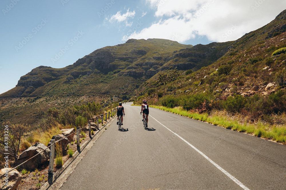 Triathletes practicing cycling on open country road