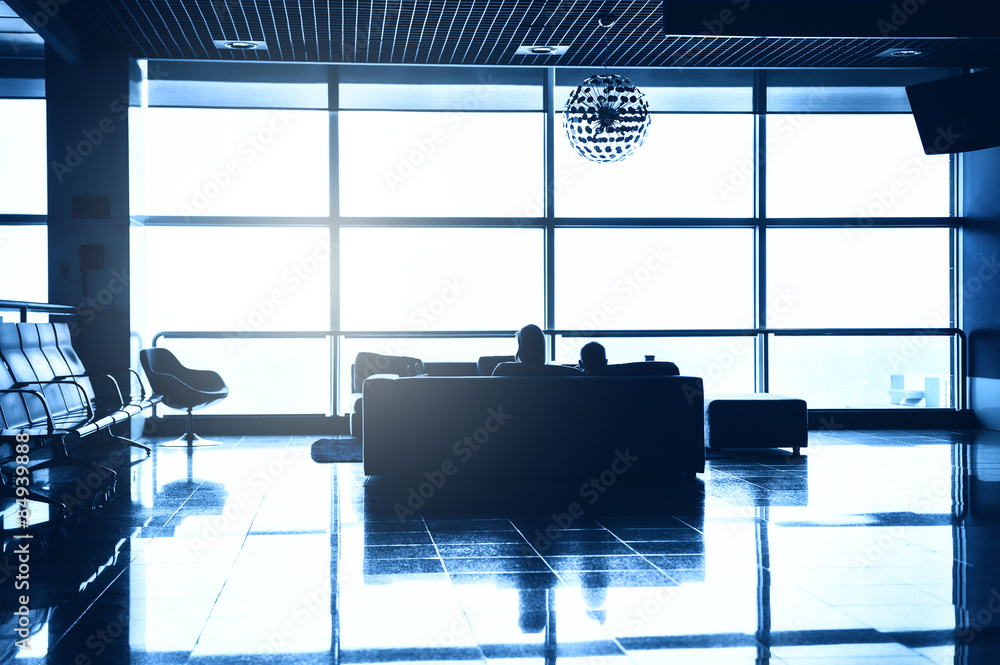 Silhouettes of people waiting for boarding at an airport