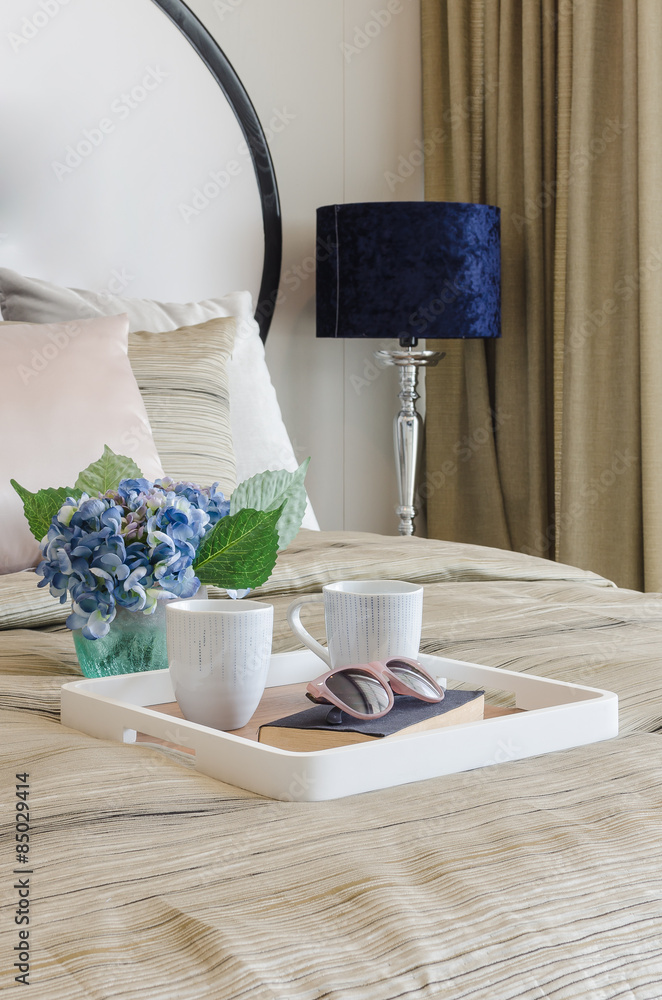 glasses on black book with cup of coffee in wooden tray