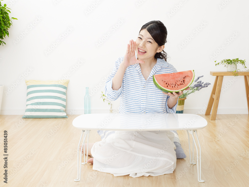 部屋で西瓜を食べる女性　呼びかける